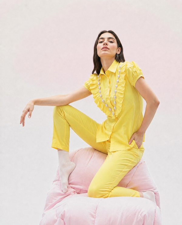 A cheerful butter-yellow cotton co-ord set featuring statement frill detailing, delicate pearl embellishments, and an easy relaxed silhouette designed for effortless everyday dressing.